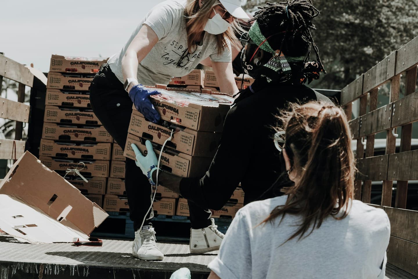 Volunteers moving boxes of food supplies at a community distribution